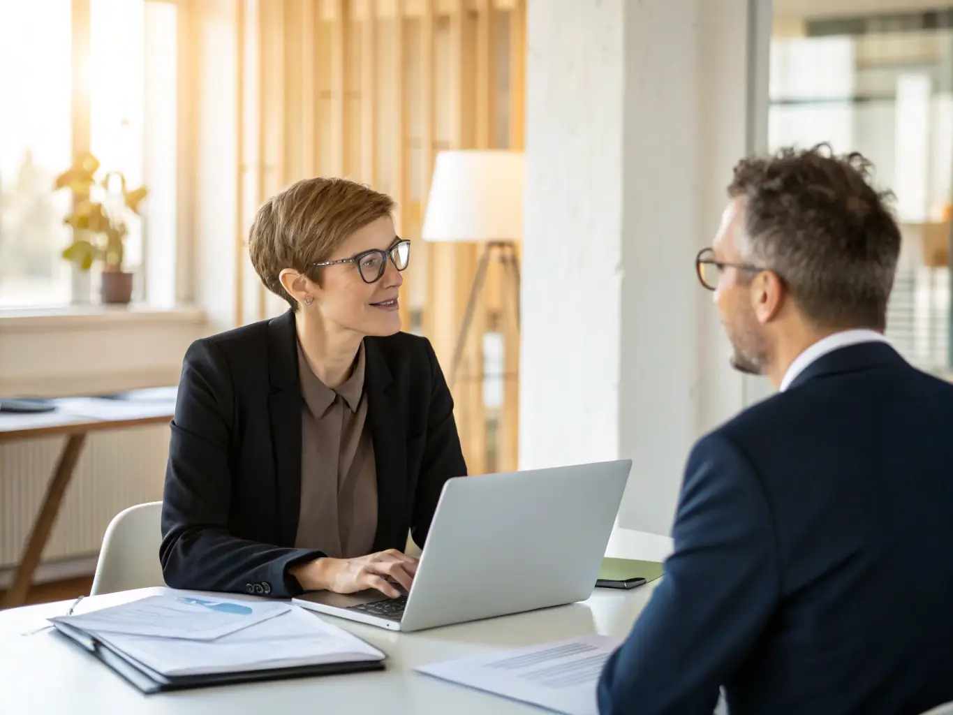 A consultant advising a business owner in a bright, modern office, illustrating personalized financial advisory services.